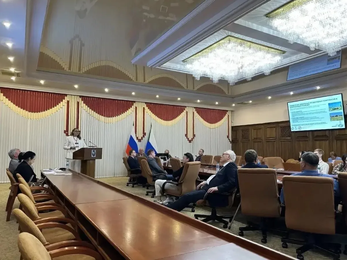 Nadezhda Filippova giving a report at the conference, with the audience listening.