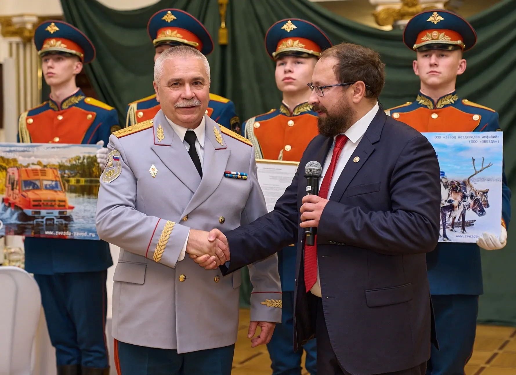 Alexander Blokhin presents a commemorative gift to the head of the university on stage.