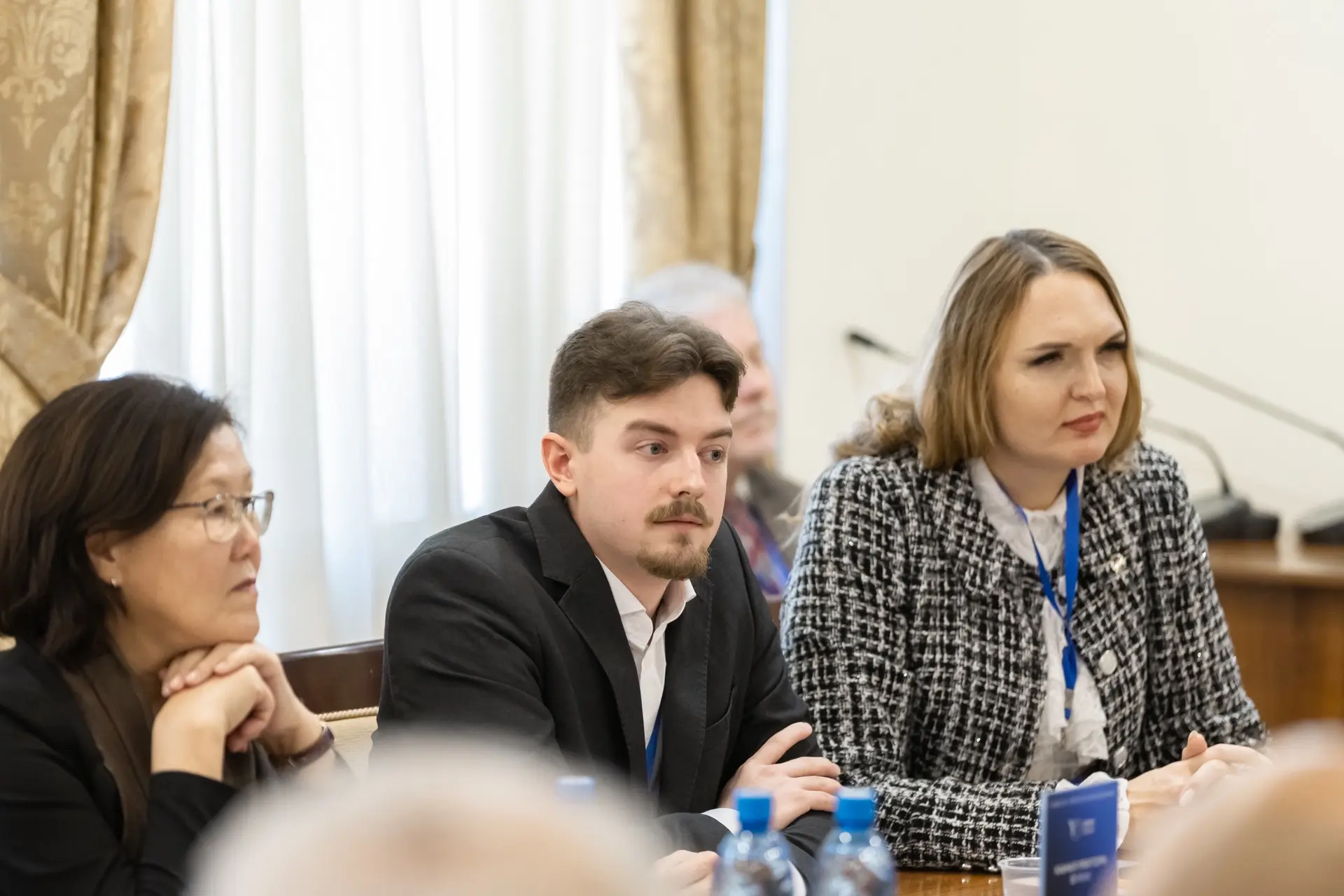Two people, a man and a woman, sit at a table at a conference.