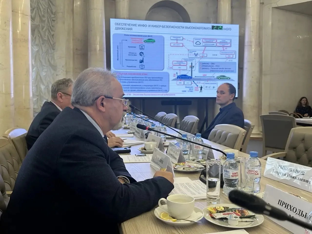 Participants of the Scientific and Technical Council meeting and presentation projection on screen